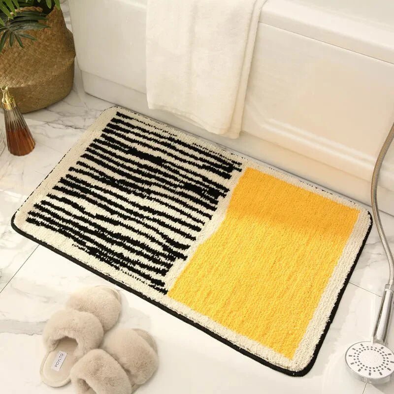 Mustard yellow and cream abstract wavy line plush bath mat on marble floor