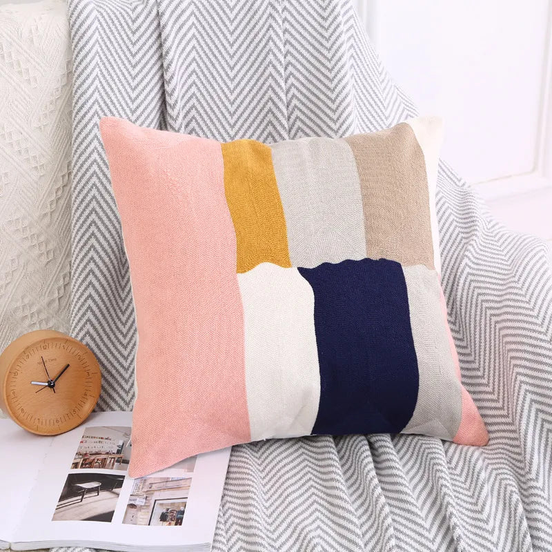 Pink and mustard Nordic embroidered pillow with geometric block pattern on cotton canvas