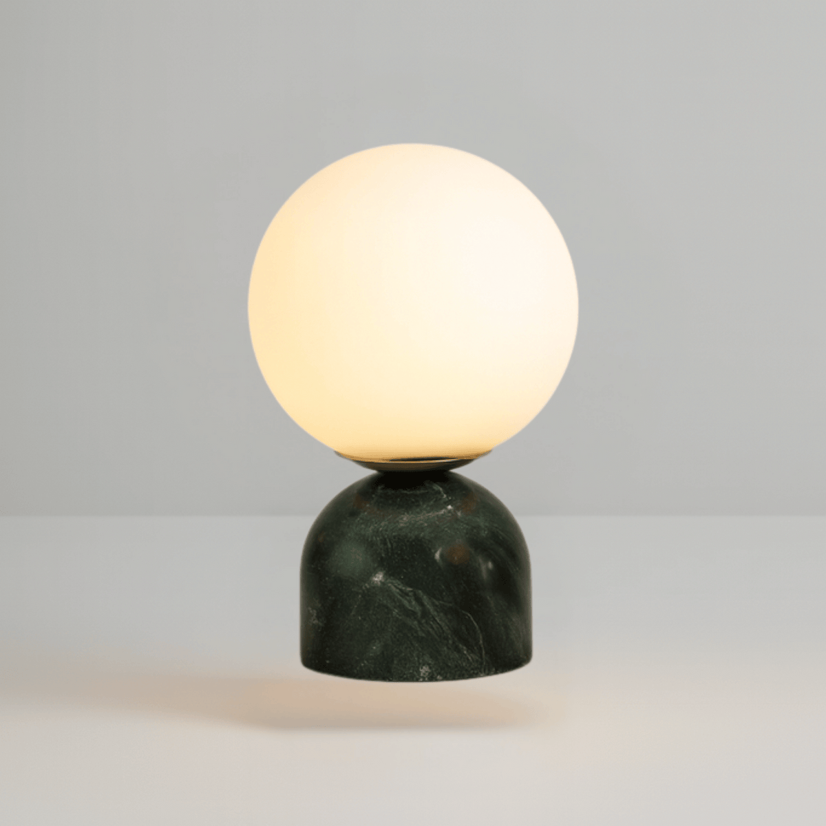 Close-up of dark green veined marble base on frosted glass desk lamp