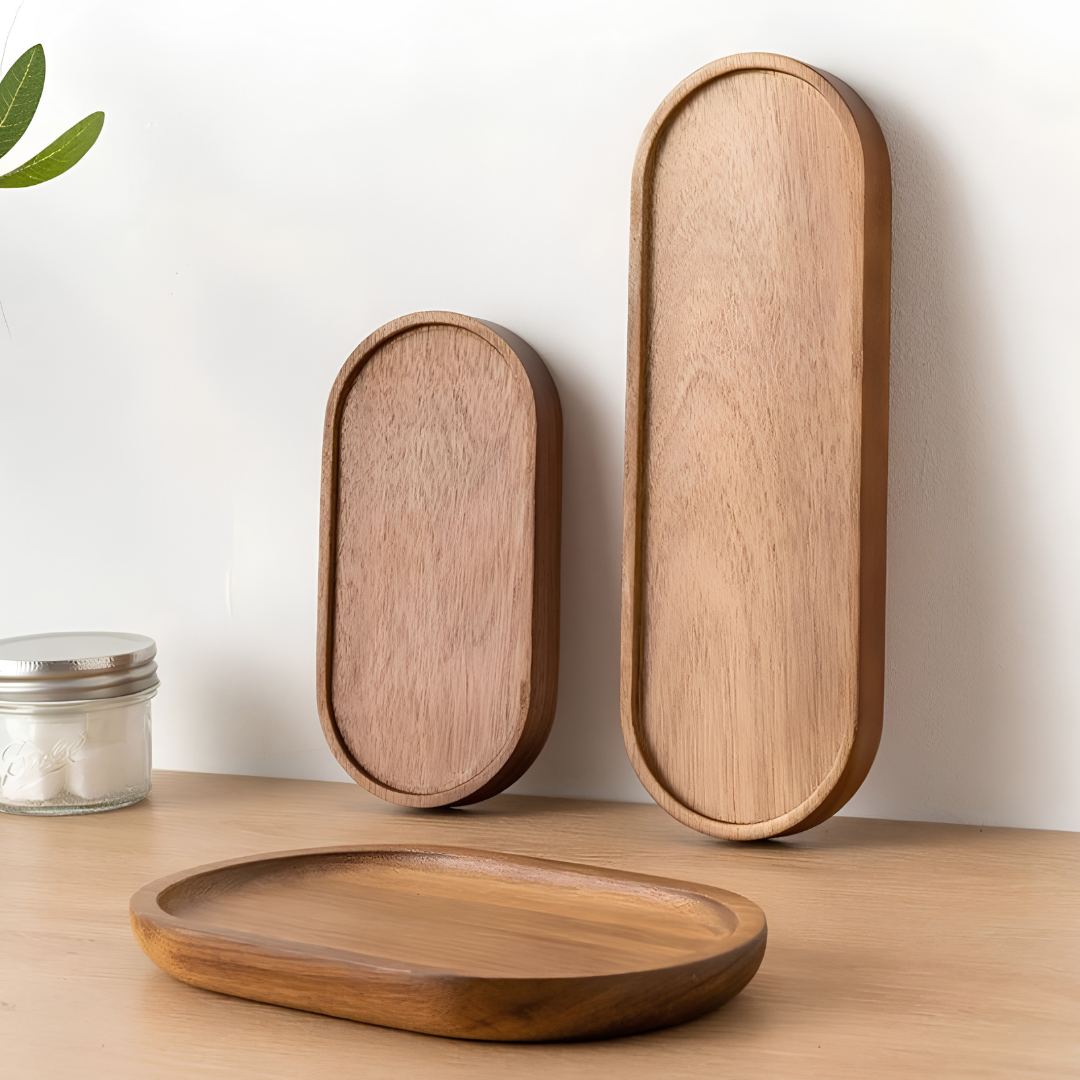 Set of three oval wooden serving trays in varying sizes and natural wood tones