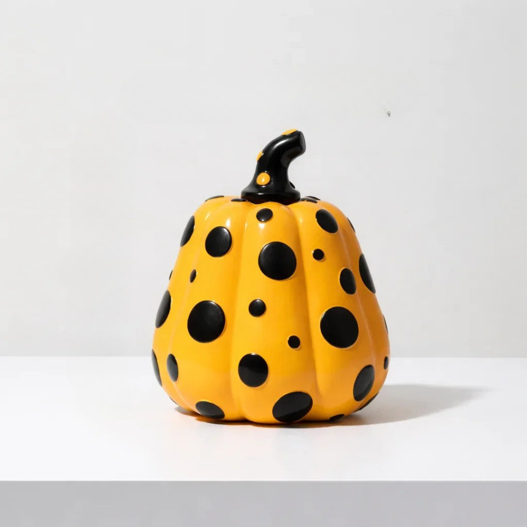Yellow resin pumpkin with irregular black polka dots and curved stem detail