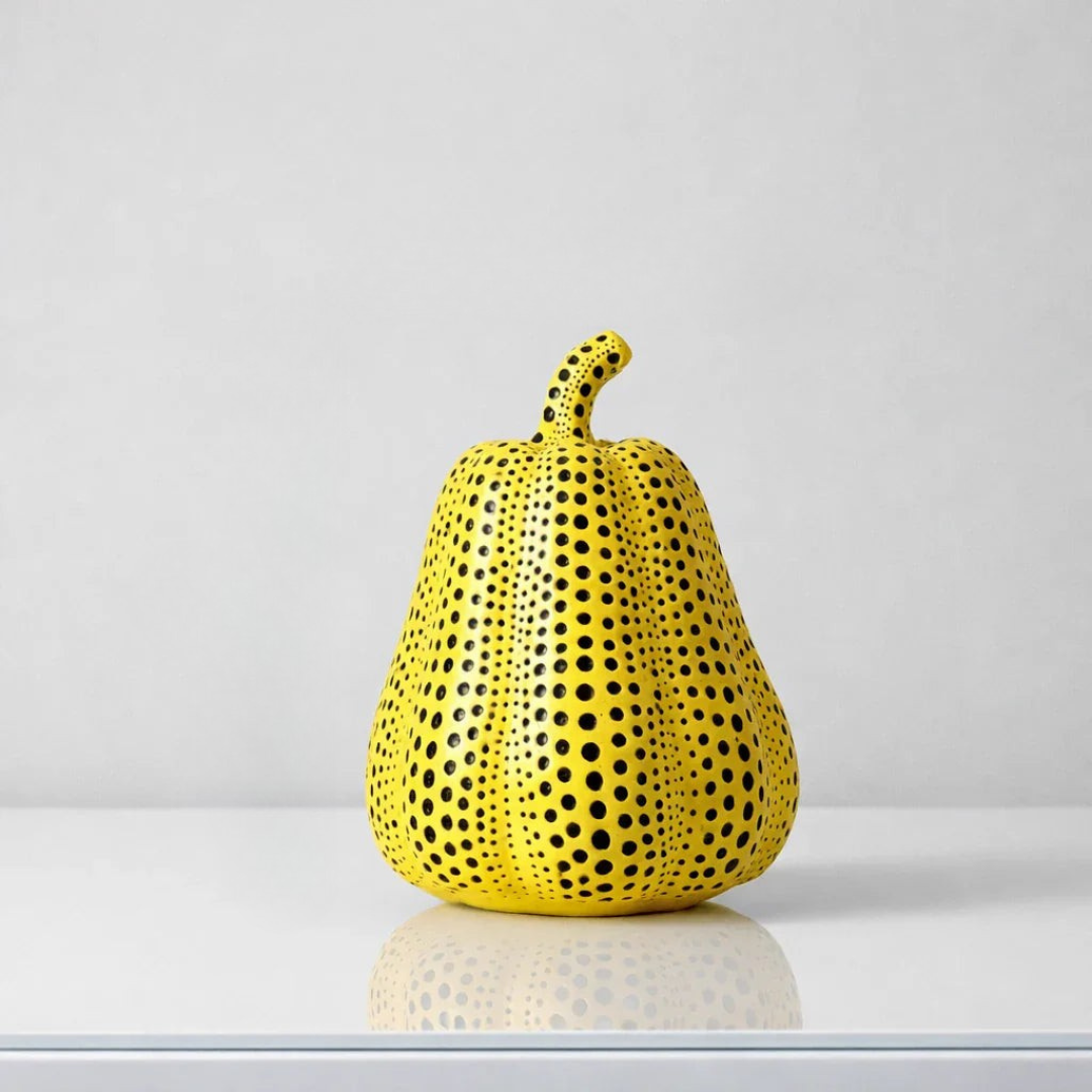 Yellow pear shaped resin sculpture with tapered black polka dot pattern