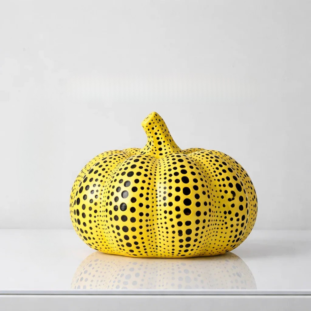 Yellow polka dot pumpkin figurine with dense central dot pattern and ribbed body