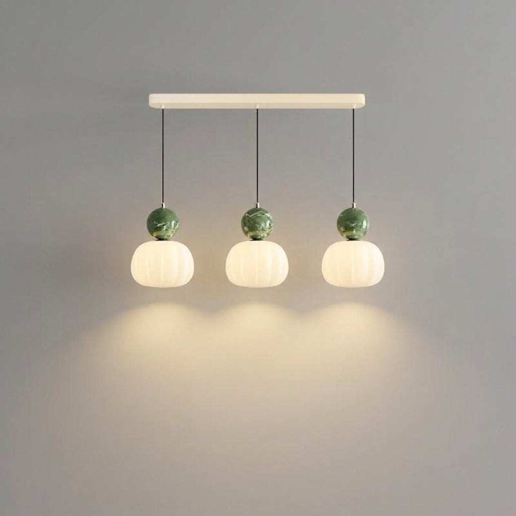 Three-light ribbed pumpkin pendant bar with green sphere