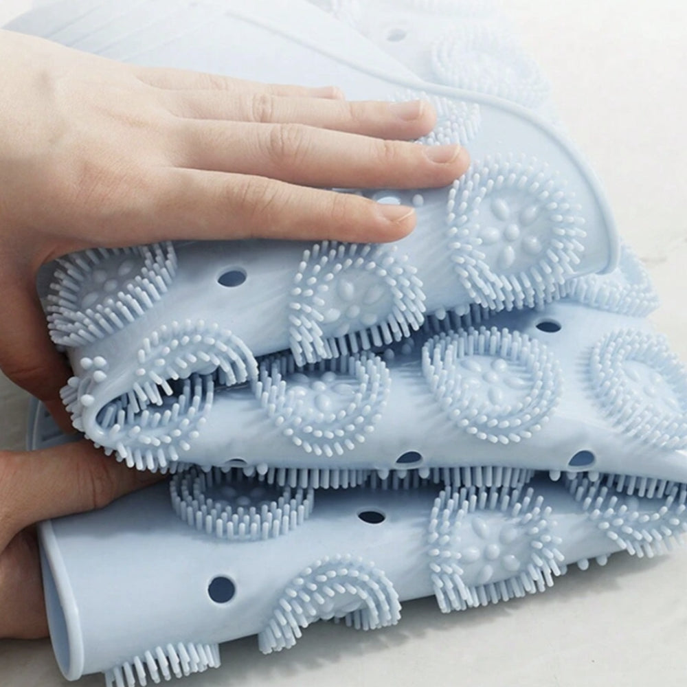 Foldable light blue silicone bath mat showing flexible texture and drainage holes