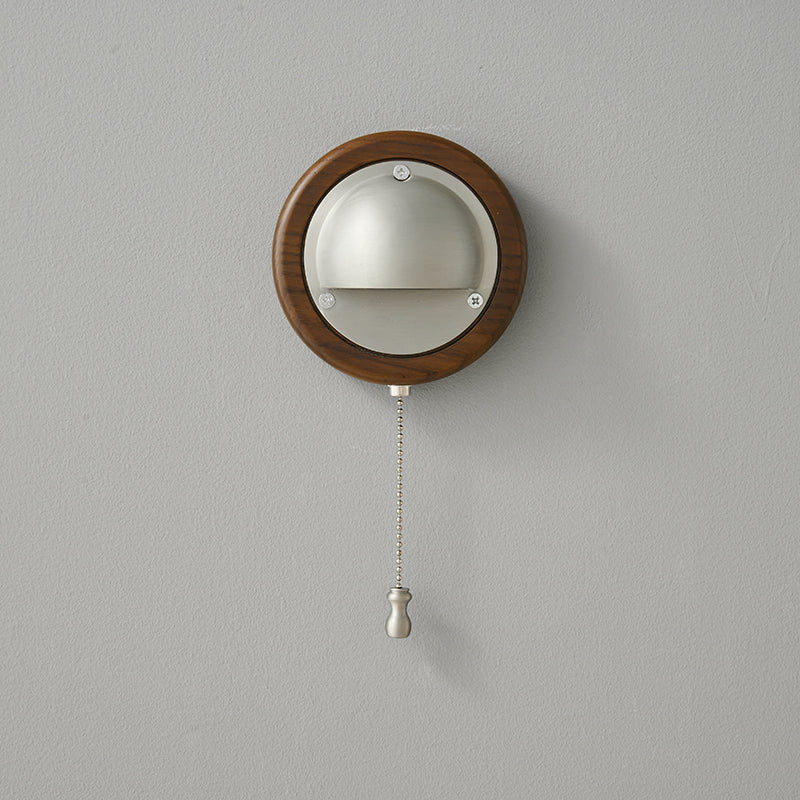 Circular wood backplate wall sconce with brushed silver dome shade detail