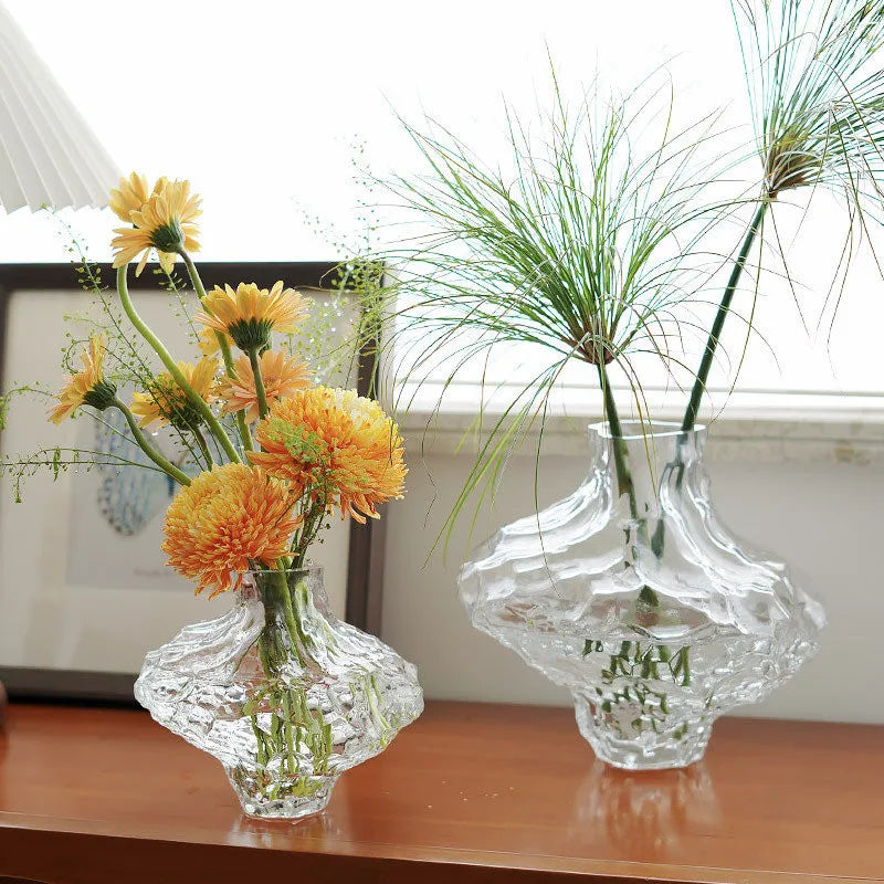 Clear crystal rippled glass vase displaying orange chrysanthemums and papyrus stems