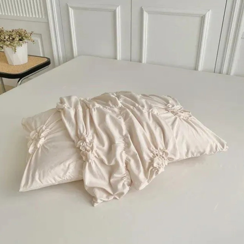 Cream ruffle duvet cover with textured flower rosettes and pinch pleats