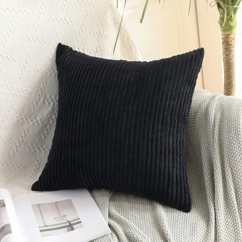 Black corduroy throw pillow with deep vertical stripes and soft texture