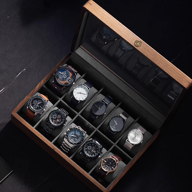 Open dark wood watch display case with glass lid and brass circular latch