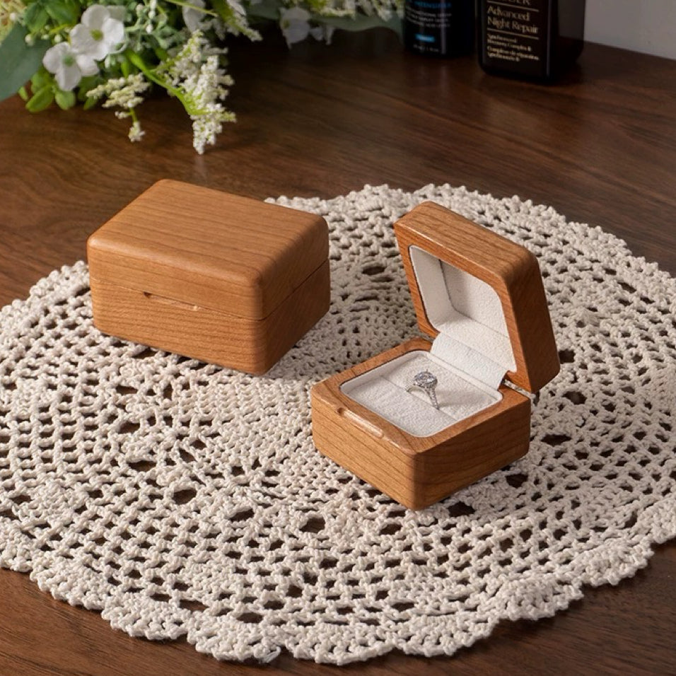 Light cherry wood ring box with diamond solitaire on crocheted doily