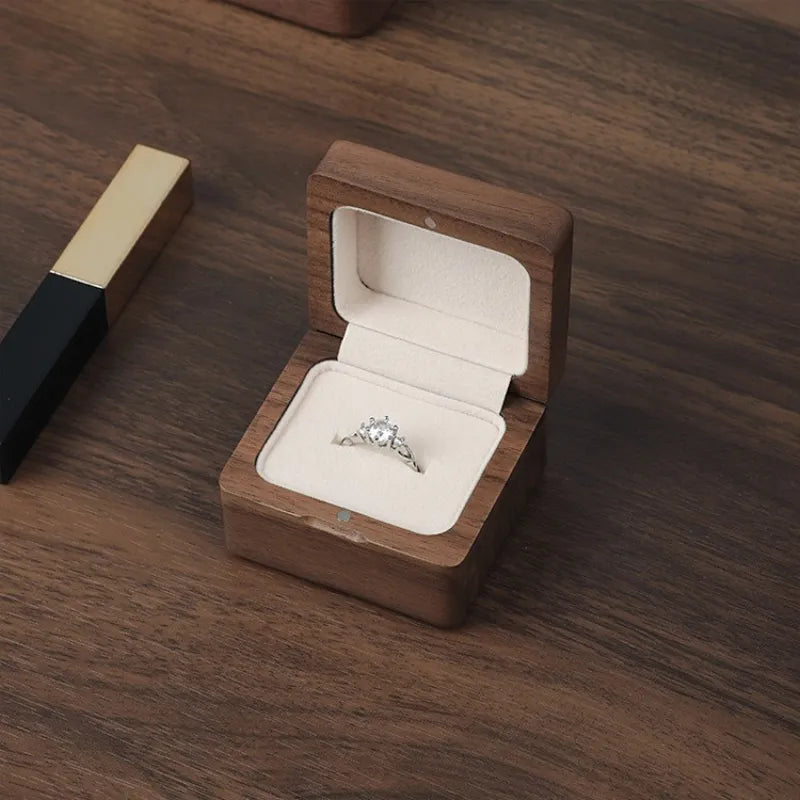 Dark walnut solid wood ring box holding round stone silver band