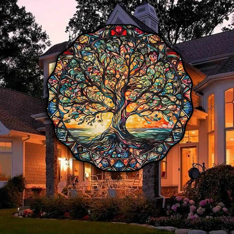 Round stained glass Tree of Life sun catcher hanging on house exterior at dusk