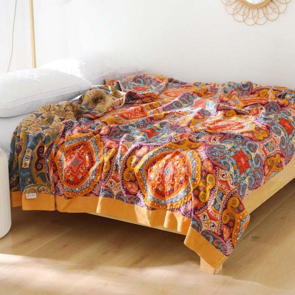 Vibrant kaleidoscopic reversible blanket draped over wooden bed frame with mustard border
