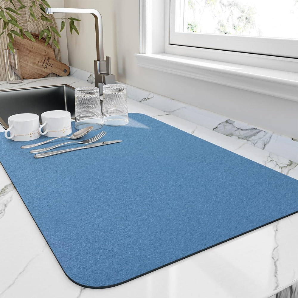 Blue quick dry dish mat holding mugs and silverware near sink