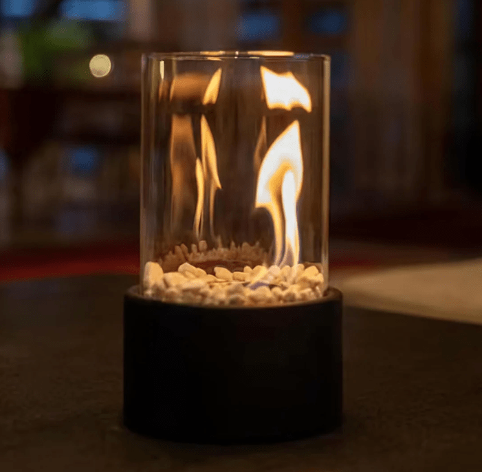 Dark gray concrete tabletop fire pit with flickering flame close-up