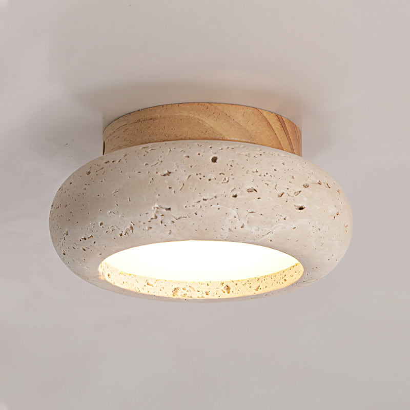 Close-up of round beige stone ceiling fixture with warm LED glow