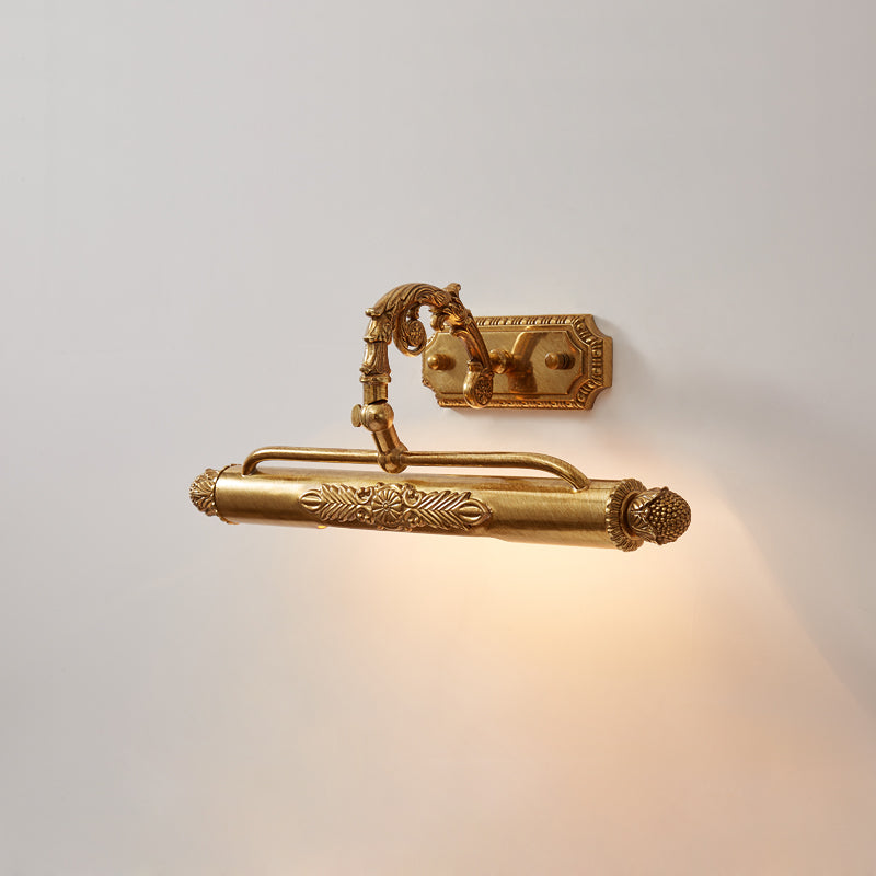 Close-up of antique brass gallery light showing embossed leaf motifs and pineapple finials