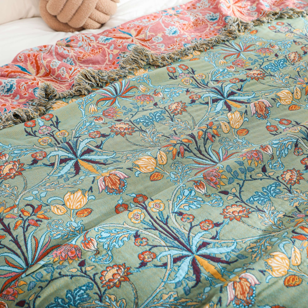 Green and pink reversible floral throw blanket laid flat showing both sides