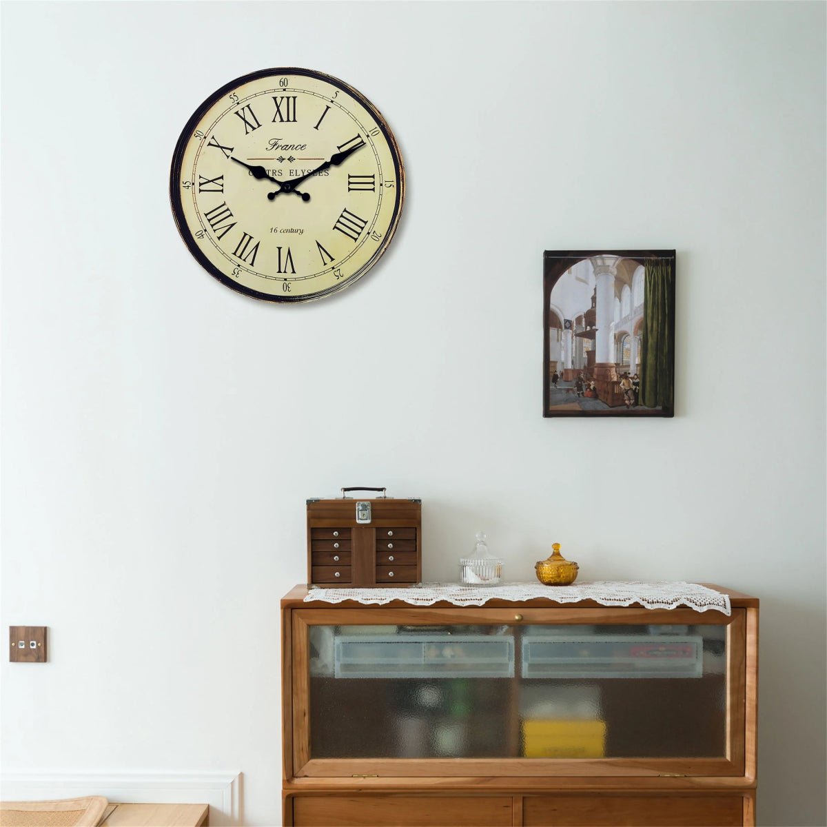 Antique round wall clock with silent quartz movement above wooden cabinet
