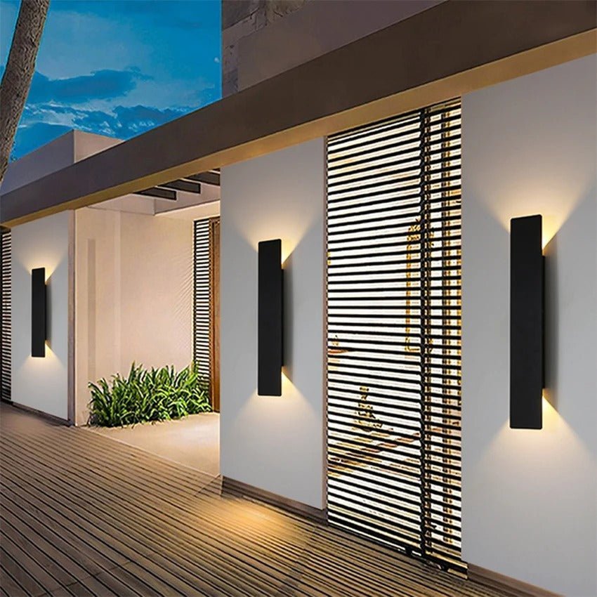 Black vertical LED wall light beside wooden deck at twilight