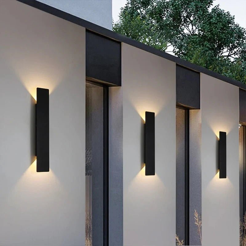 Set of three black modern outdoor wall lights on building facade