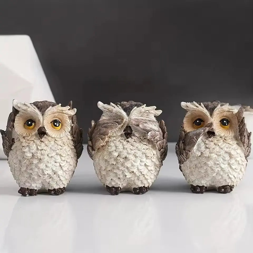 Hand-carved owl statues showing see hear speak no evil expressions