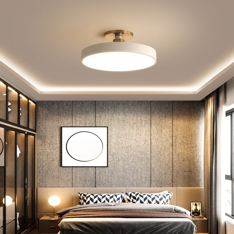 Maintained House Macaron Drum LED Ceiling Light - White in a bedroom with wood-panel walls