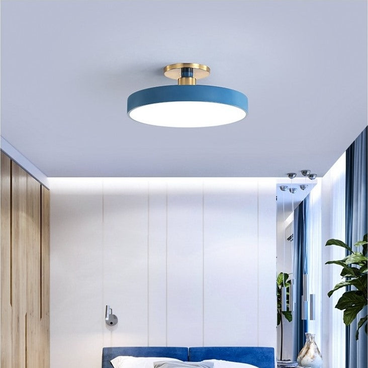 Maintained House Macaron Drum LED Ceiling Light - Blue above a bed with white wall panels