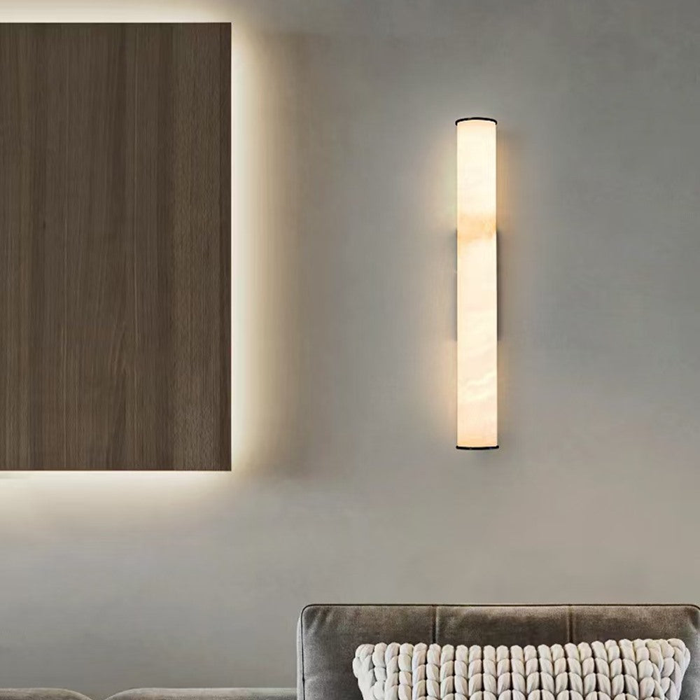 Maintained House Marble Tube Wall Sconce - Lit on a living-room wall beside a wood panel