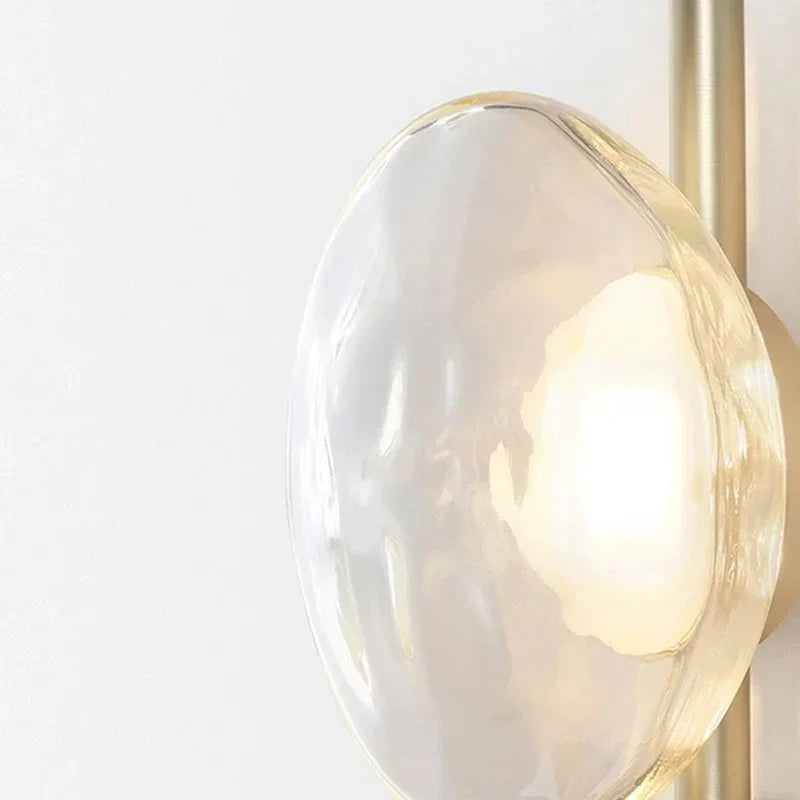 Maintained House Nordic Rippled Glass Wall Sconce - Close-up of the rippled clear glass shade and brass rod