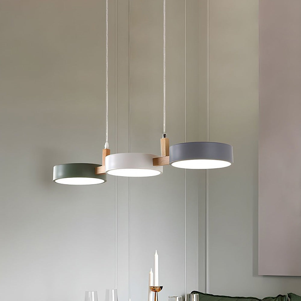 Maintained House Nordic Wood Drum LED Pendant - Green, White and Gray drums hung at an angle in a bright room
