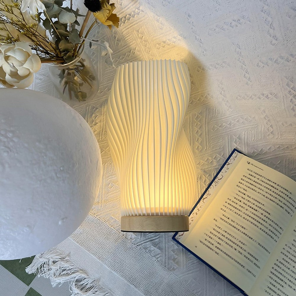 Maintained House Sculpted Wave Table Lamp - Curve lamp beside an open book