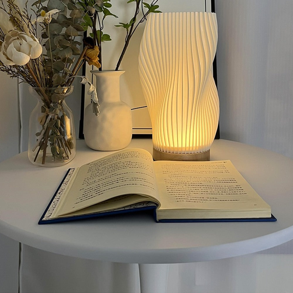 Maintained House Sculpted Wave Table Lamp - Curve lamp on a round table with a book